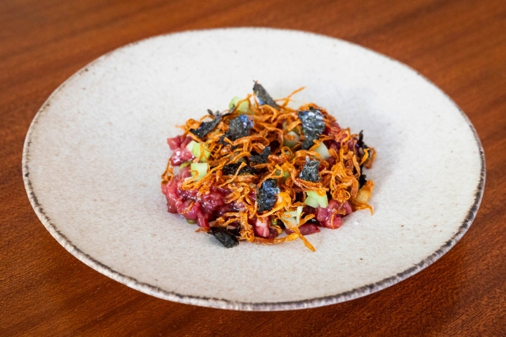 O tártaro de novilho com temperos asiáticos, cebola frita, alga nori e pepino expressa um pouco do percurso profissional do chef