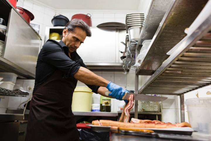 Juan Carlos Calvo, cortando la panceta en la cocina del Café Chicago. 