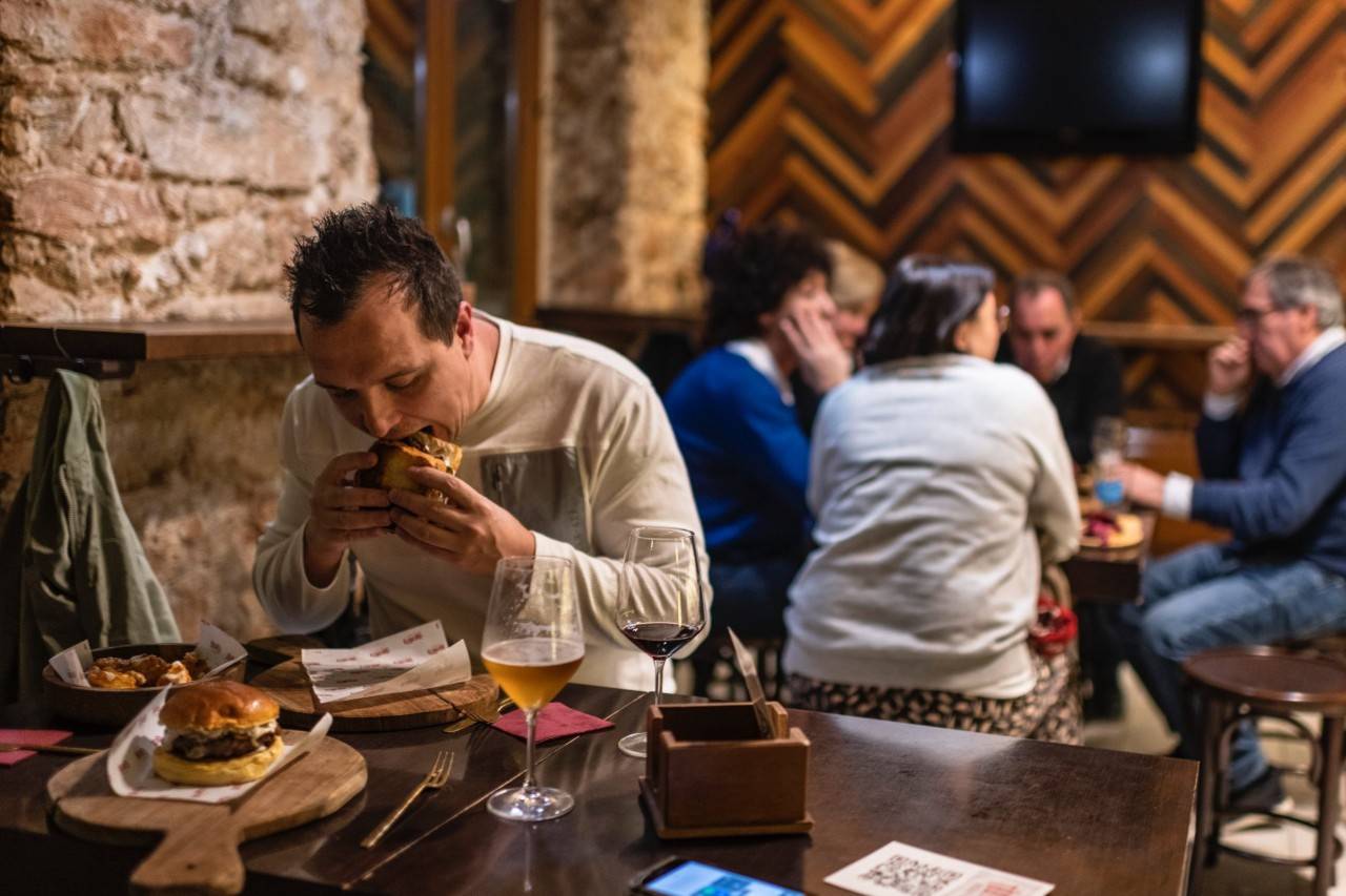 Un cliente degustando una hamburguesa de La Taberñita