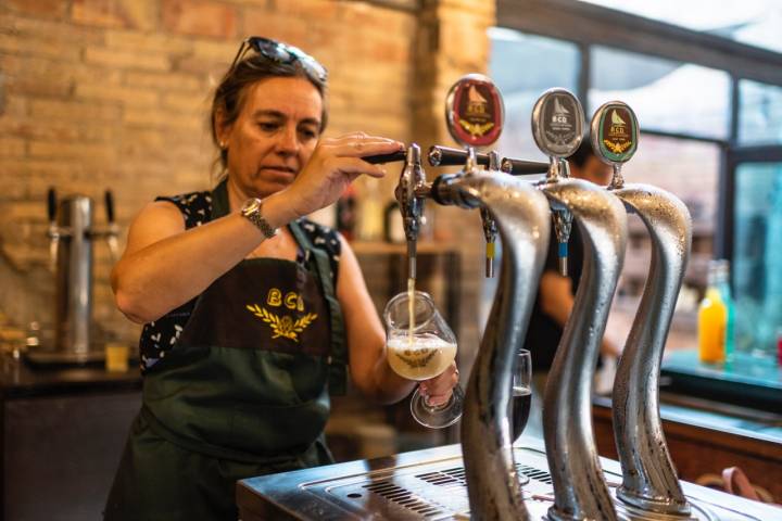 Natàlia sirviendo una cerveza.