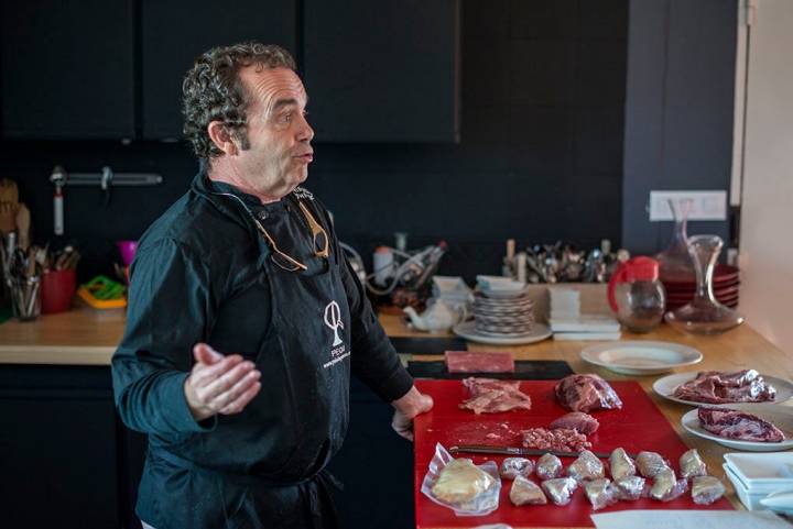 Carlos Tristancho a punto de cocinar el cochinillo, junto a otras carnes.