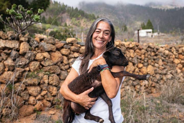 Pilar Carballo sujeta a un corderito negro de la finca La Jara (Arafo, Tenerife).