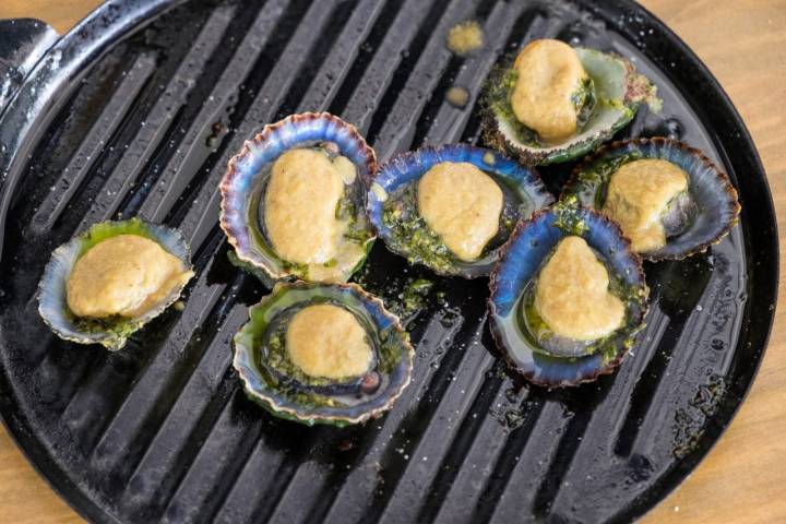 Lapas asadas con picada de ajo y perejil y crema ligera de plátano frito.