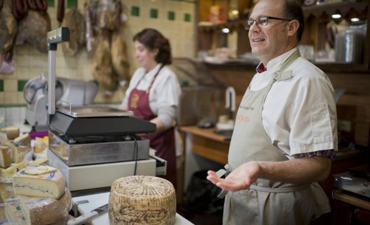 Raúl y Virginia ilustrando a un cliente sobre el queso que ha pedido.