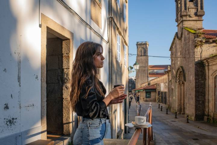 Mujer tomando café con vistas a la Iglesia de San Fiz