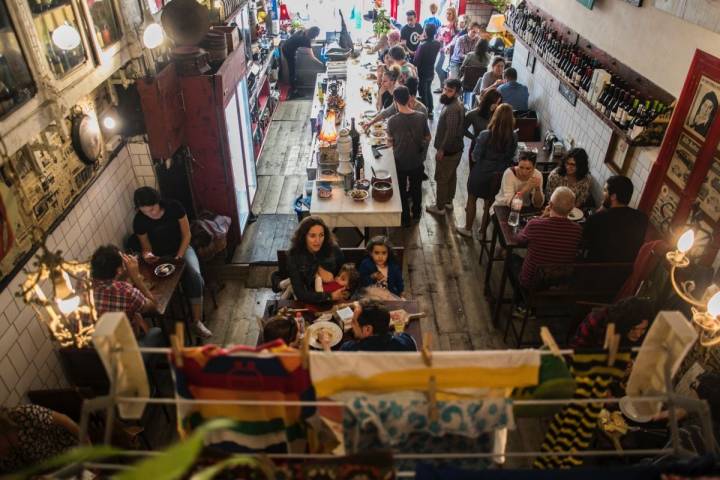 Familias, amigos, parejas... se acercan a la 'Bodega La Peseta' para probar su arroz cocinado sobre una calabaza.