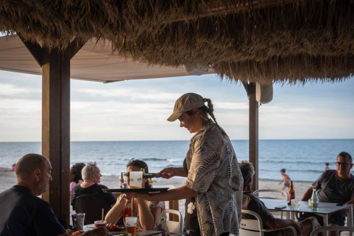 Camarera sirviendo a clientes en el chiringuito