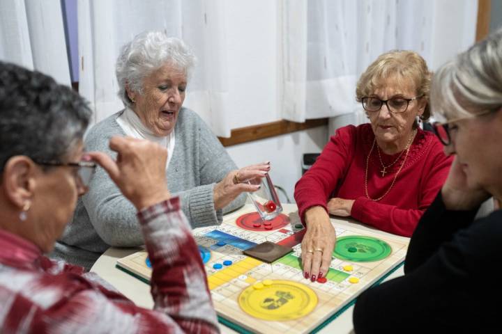 Un grupo de amigas juega al parchís al fondo del bar.