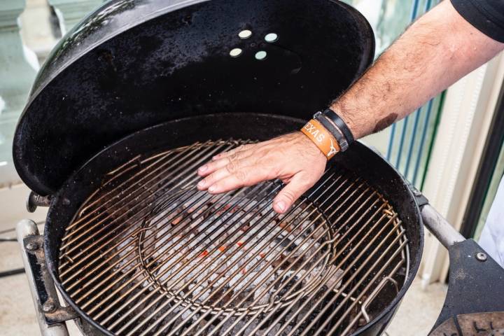 Mano sobre las brasas para medir la temperatura