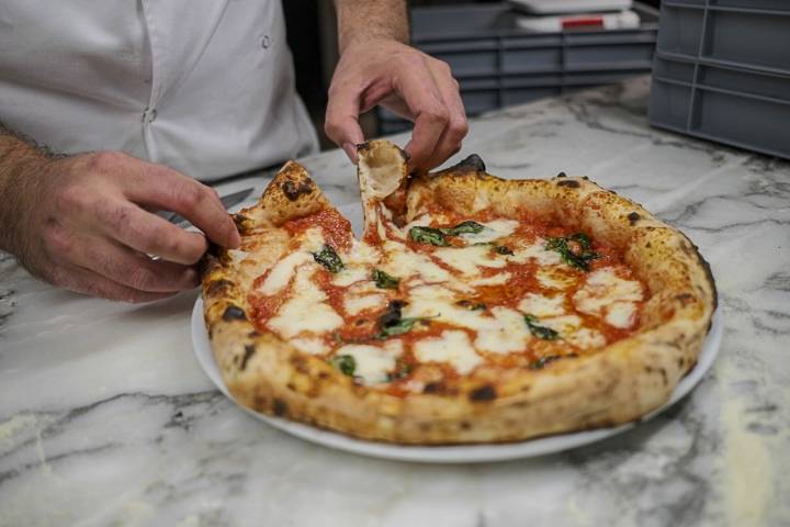 Adrià muestra cómo queda el borde de la masa de la pizza estilo napolitana.