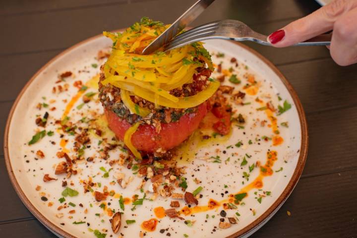 Tomate a la brasa con pesto casero y almendras tostadas.