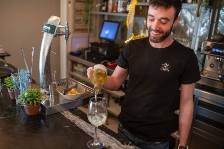 Adrián sirviendo vino sobre la elegante barra de mármol del restaurante.