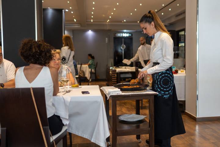 Sirviendo un arroz a unos comensales en la sala de El Campero.