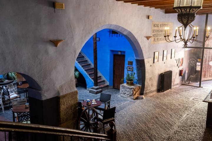 Entrada al mesón, con un arco casi redondo que da paso a un espacio azul.
