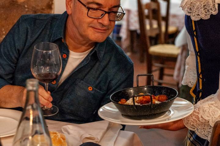Un comensal recibiendo un típico plato de migas.