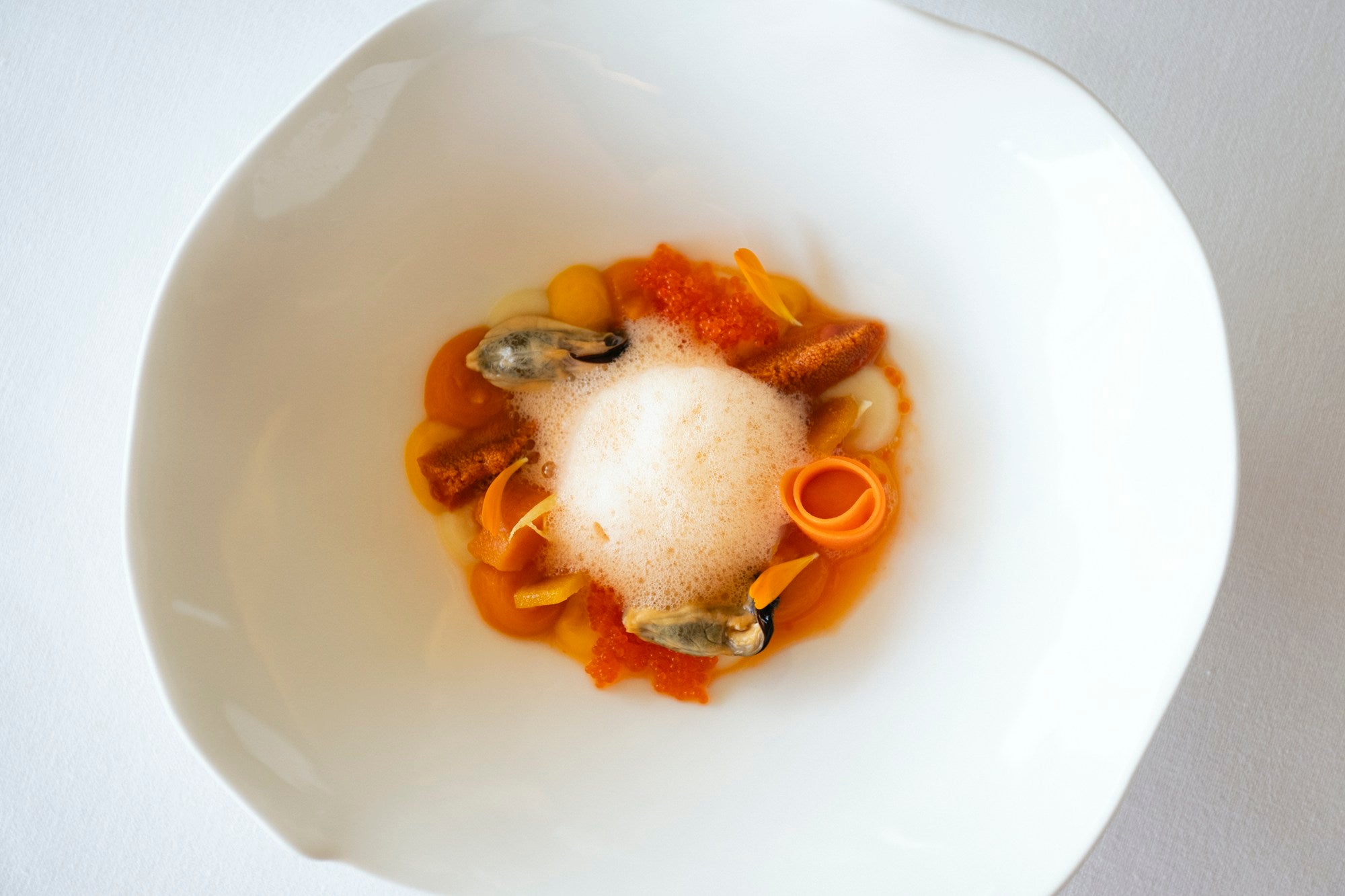 La ensalada de naranja va con pures de zanahoria y boniato, mejillones, erizo de mar y huevas de pez volador.