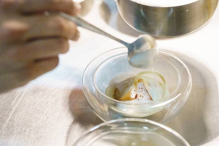 Masa de donut con crema de vainilla, lima y jengibre, regada con tom kha gai y maíz inflado