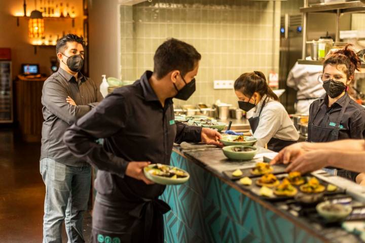 Roberto Ruiz en su cocina de Barracuda junto a más cocineros trabajando.