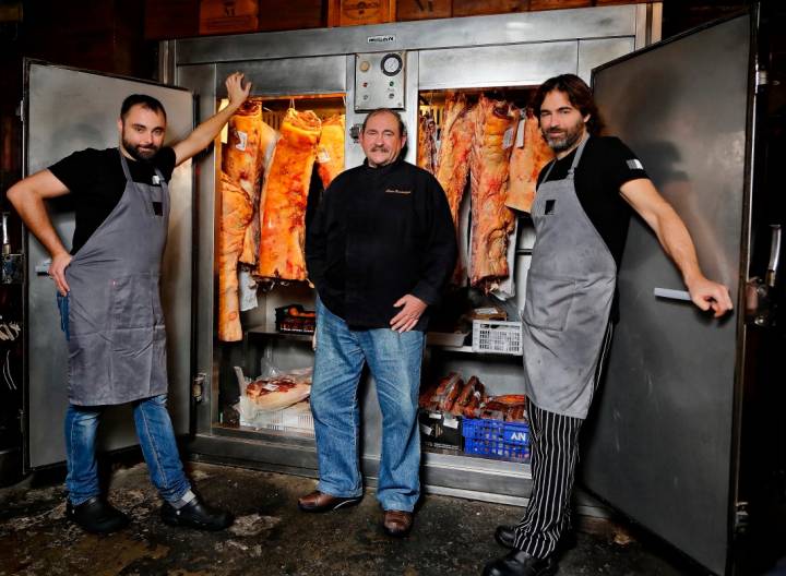 Matías Gorrotxategi con sus dos hijos, Xavi e Iñaki, junto a las neveras de la carne de vacuno preparadas para asar a la parrilla.