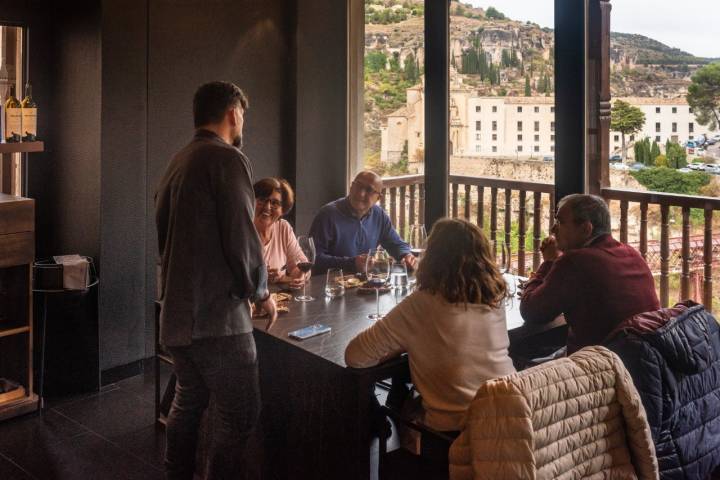 Jesús Segura conversa con unos clientes en el comedor, con vistas a las Hoces del Huécar