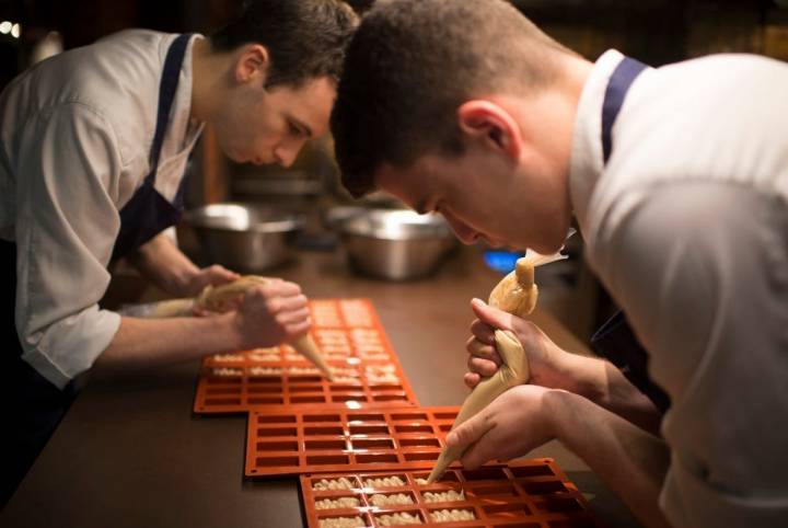 Dos cocineros rellenan unos moldes