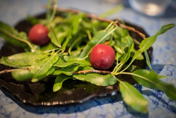 Cerezas falsas, rodeadas de hojas