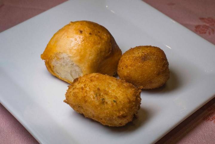 Un bollo 'preñao' y una croqueta de cocido antes del primer plato.