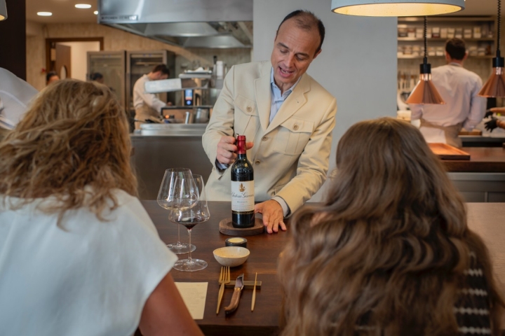El sumiller mostrando una botella de vino.