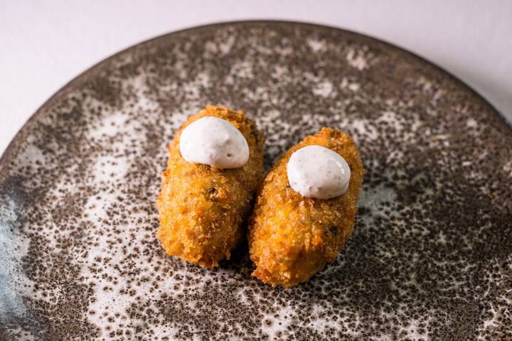 Croquetas con cocido de cordero, nata de trufa y orégano.