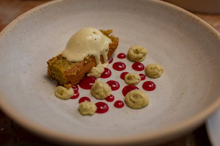 Bizcocho con helado de pistacho, frambuesa y crema de pistacho.