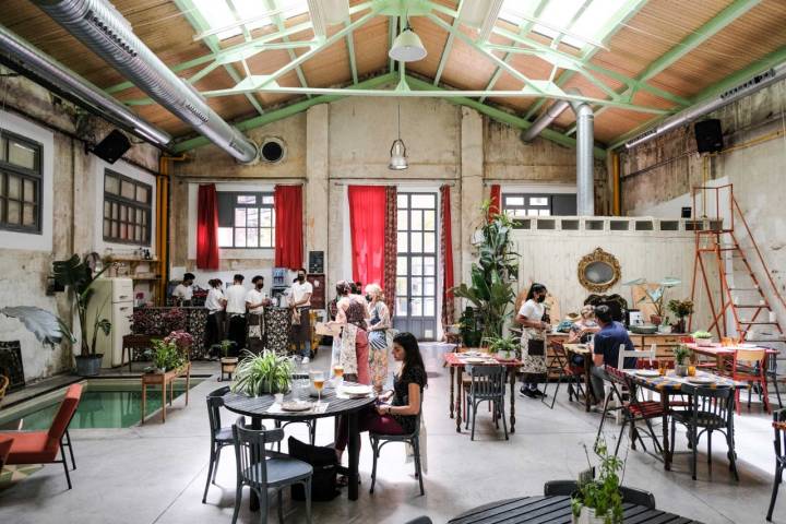 La sala de La Cantina Divina, ubicada en Nave María, muestra una decoración de colores mezclados y multitud de plantas.