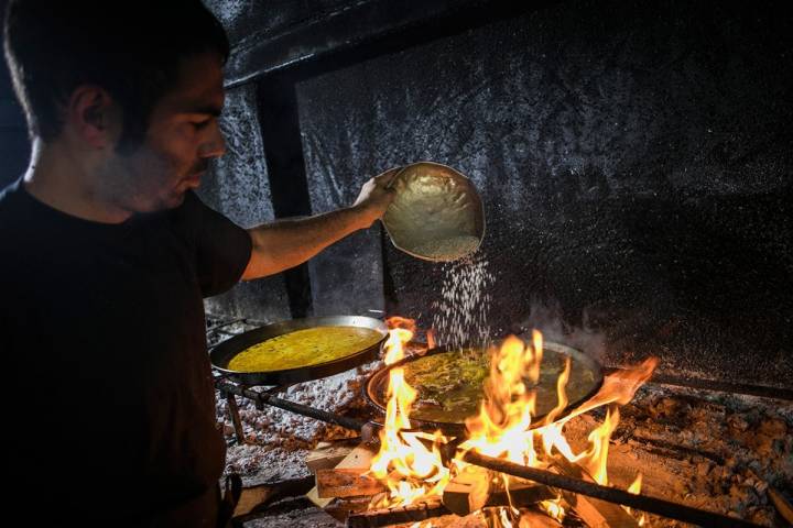 Marcos, a los mandos de las paellas, esparce el arroz que no se tocará hasta pasados 18 minutos.