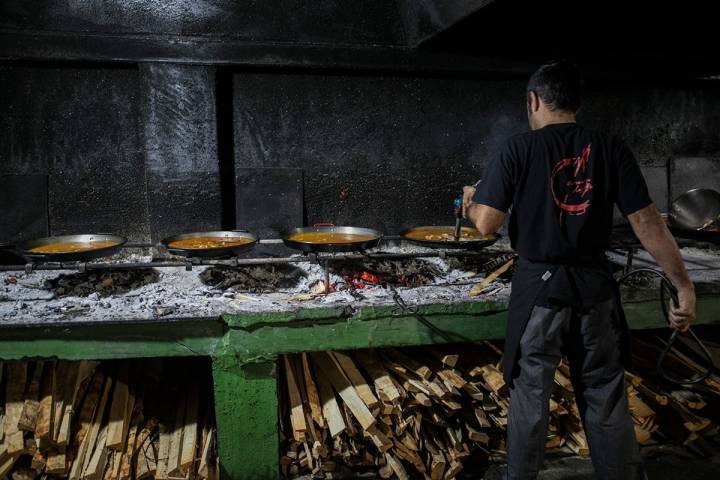 Marcos atento a varias paellas a la vez, cada una en un estadio diferente.