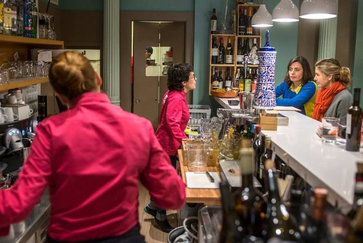 Carmen, atendiendo en la barra a unas clientas que preguntan por los platos del día.