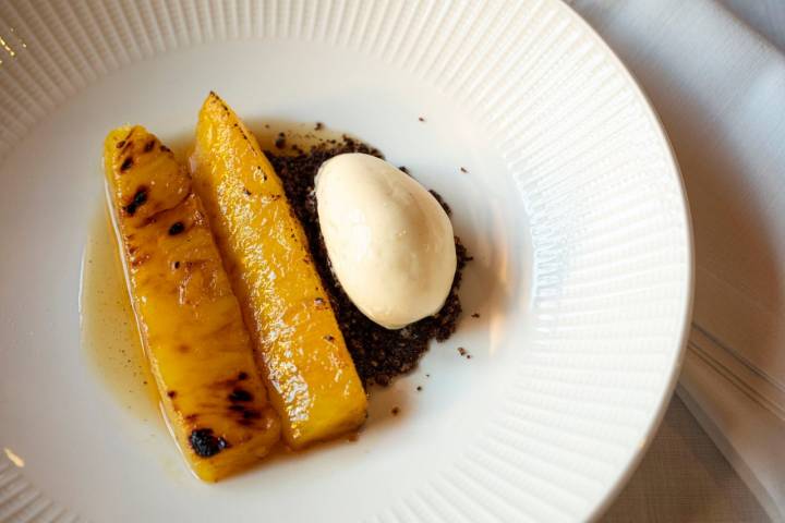 Postre de piña a la brasa con helado de vainilla hecho en casa.