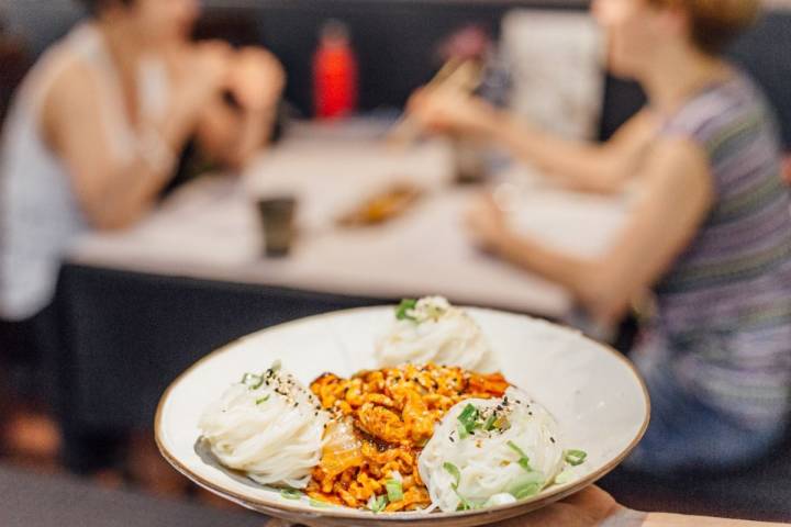 Plato de Kimchi bokum gucsu o fideos y lomo de cerdo salteado del restaurante coreano Seoul, en Barcelona.
