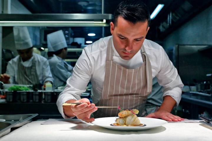 El chef José Manuel de Dios dando los últimos retoques a un plato de bacalao.