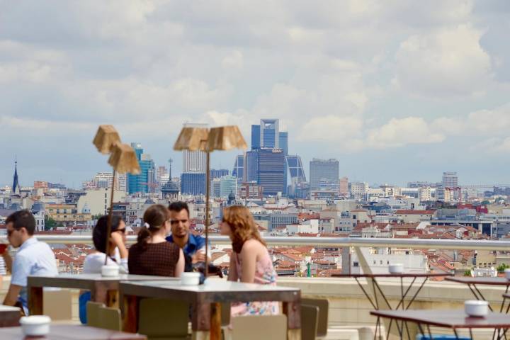 Cuatro personas conversan sentados en la terraza de la azotea del Círculo de Bellas Artes.