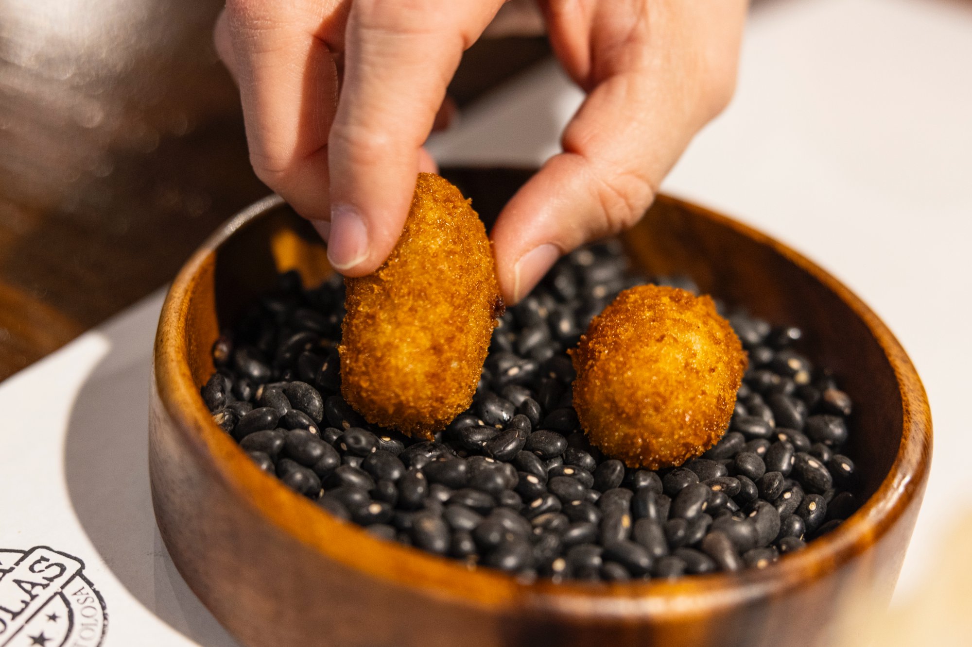 Aperitivo de bienvenida, croquetas, caldo, lengua y crujiente de chuleta.