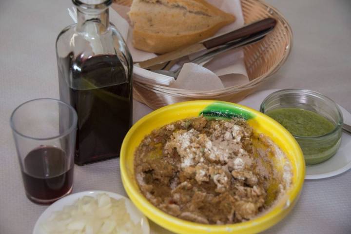 Plato de escaldón de gofio junto al vino en una mesa del guachinche Quintero, en Tenerife.