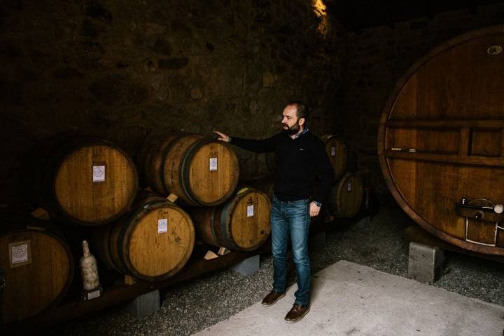 Carlos junto a las barricas en las que guardan la producción hasta su embotellamiento.