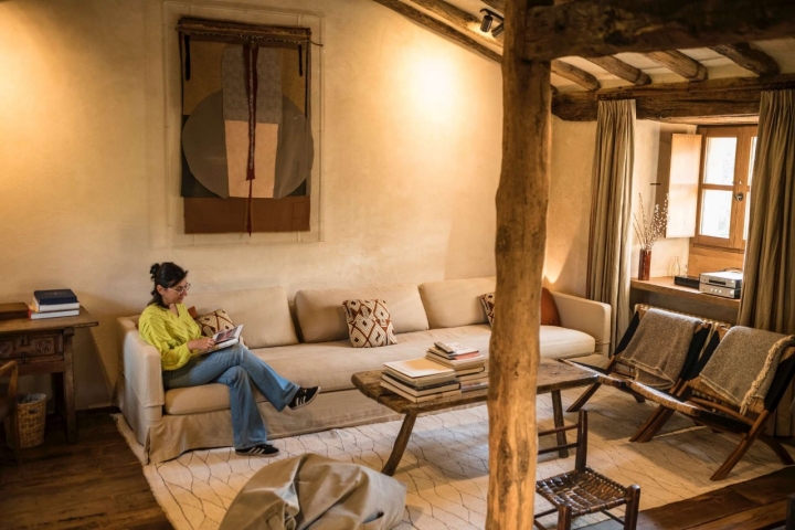 Una mujer lee en el salón de la cabaña más grande, Arce.