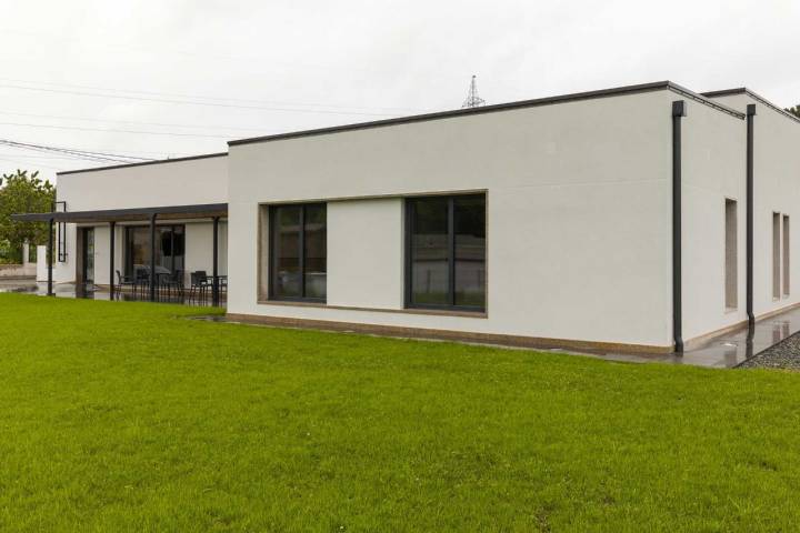 Edificio del Albergue San Lorenzo de Bruma con sus líneas rectas y blancas rodeado de césped.