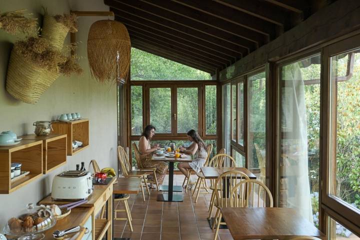 Dos mujeres desayunando en una de las mesas de la galería.