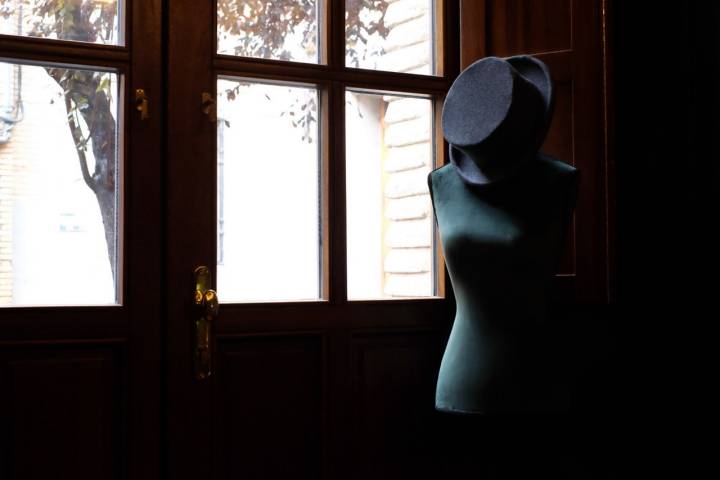 Un maniquí con chistera junto a la ventana, en el restaurante.