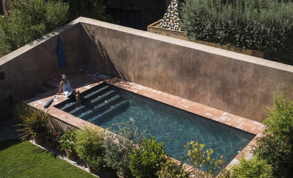 La piscina, resguardada de miradas, en la masía.