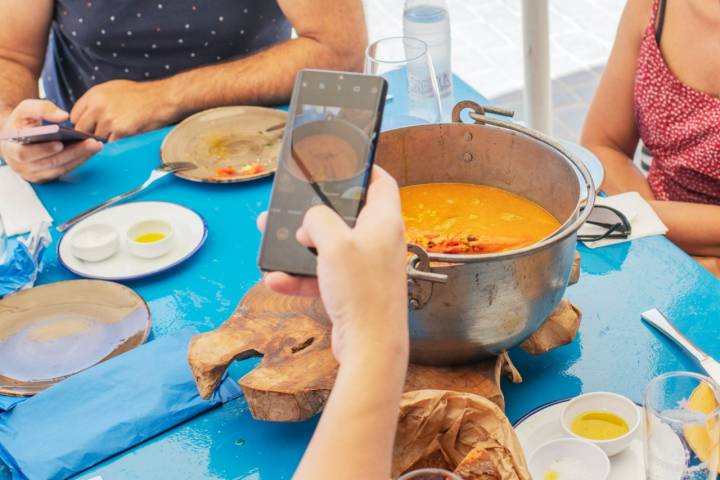 Haciendo una foto a la cazuela de arroz meloso en el chiringuito Tropical