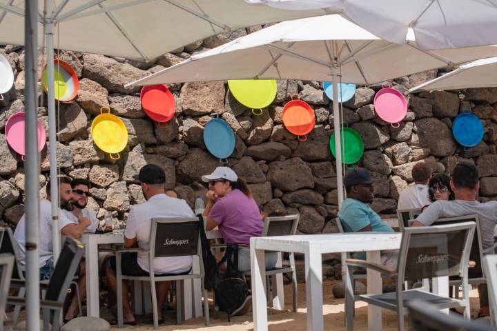 Terraza, decorada con paellas de colores, del chiringuito Tropical