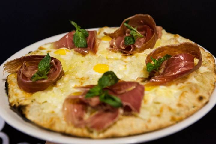 Pizza de huevos rotos con jamón.