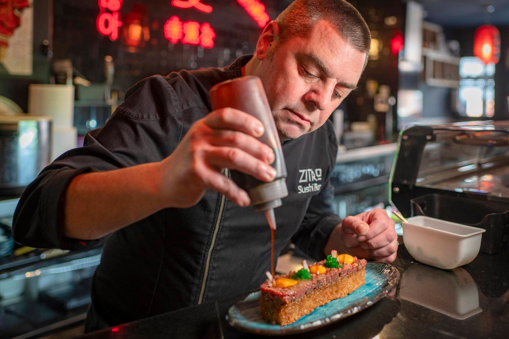 Rubén Ortiz termina un original steak tartar en la barra de su restaurante asiático ‘Zitro’, en Tomelloso. (Ciudad Real, Castilla-La Mancha). Foto: Sofía Moro